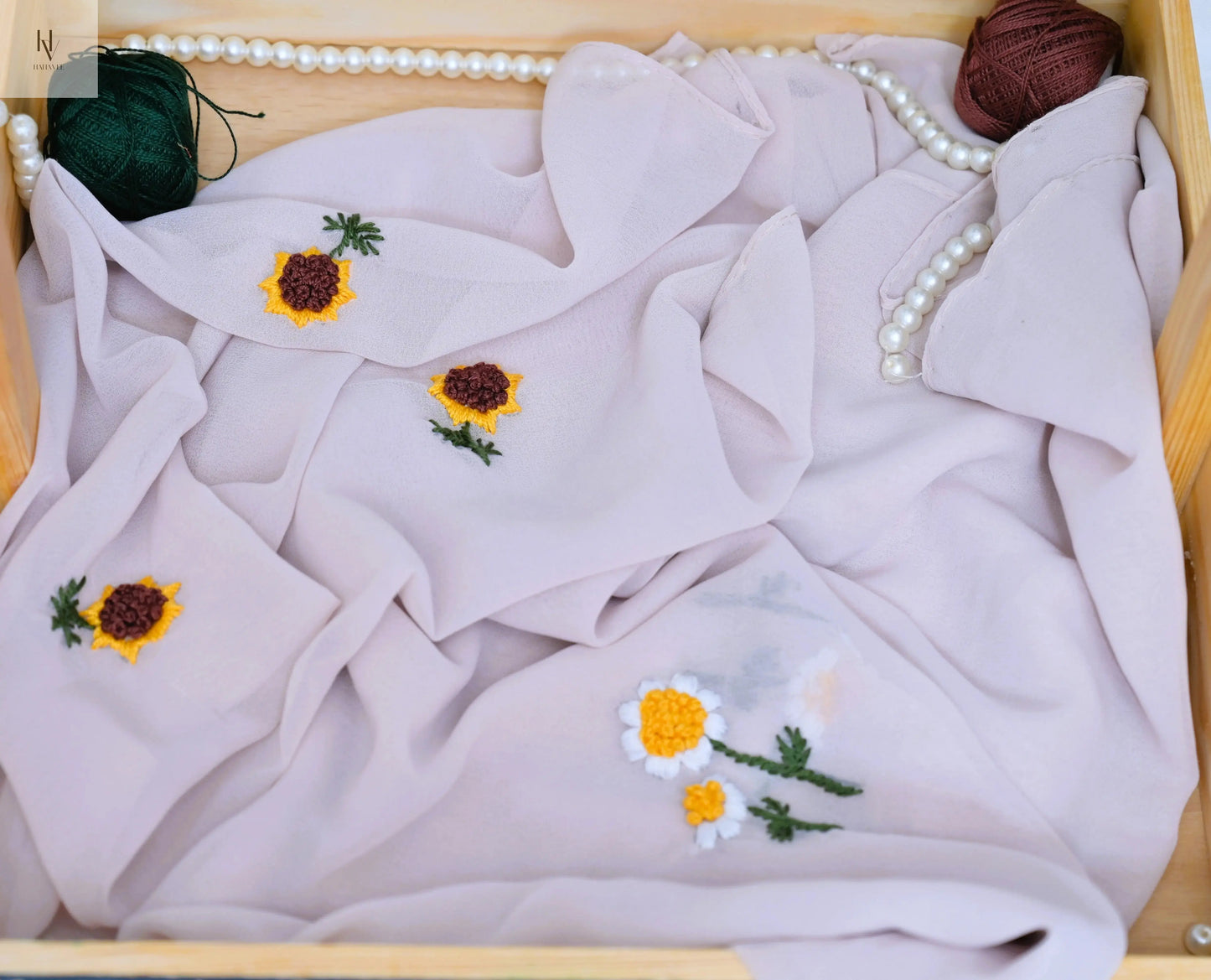 White hijab with embroidered flowers in a wooden frame
