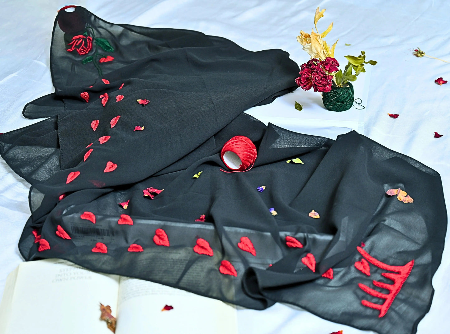 Black hijab with red floral and heart patterns on a white background
