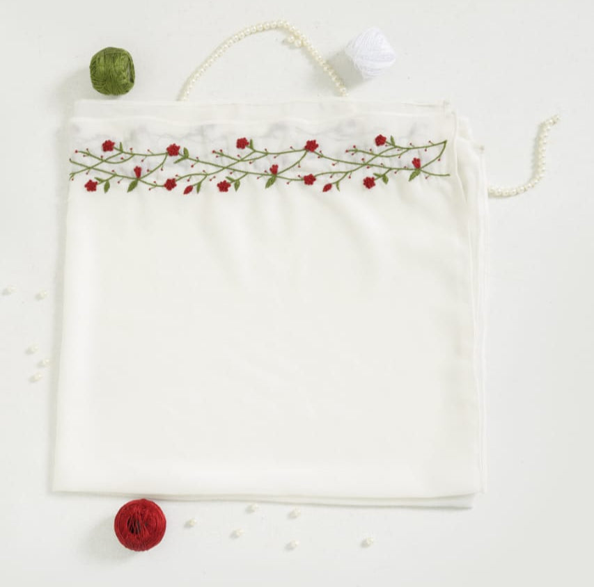 Elegant white hijab with embroidered design on a white background