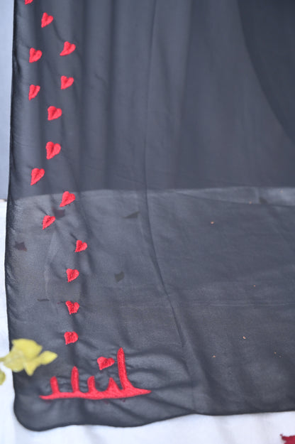 Black fabric with red heart patterns and yellow flower on a white background